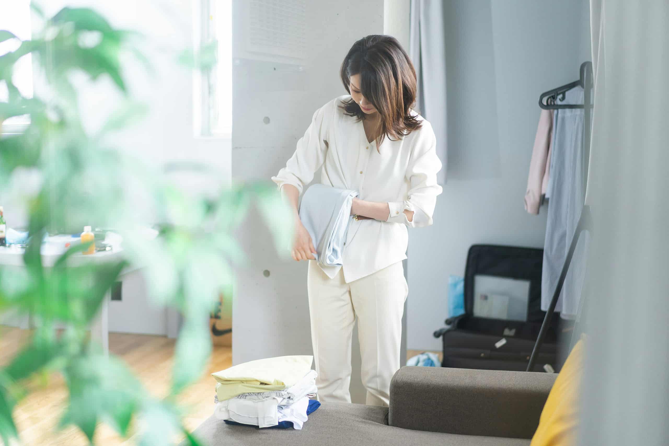Nanny organizing clothes and setting up a clean modern nursery